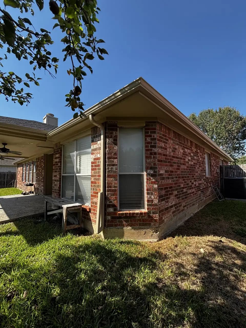 Gutters along a brick home roofline by Rugged American Exteriors