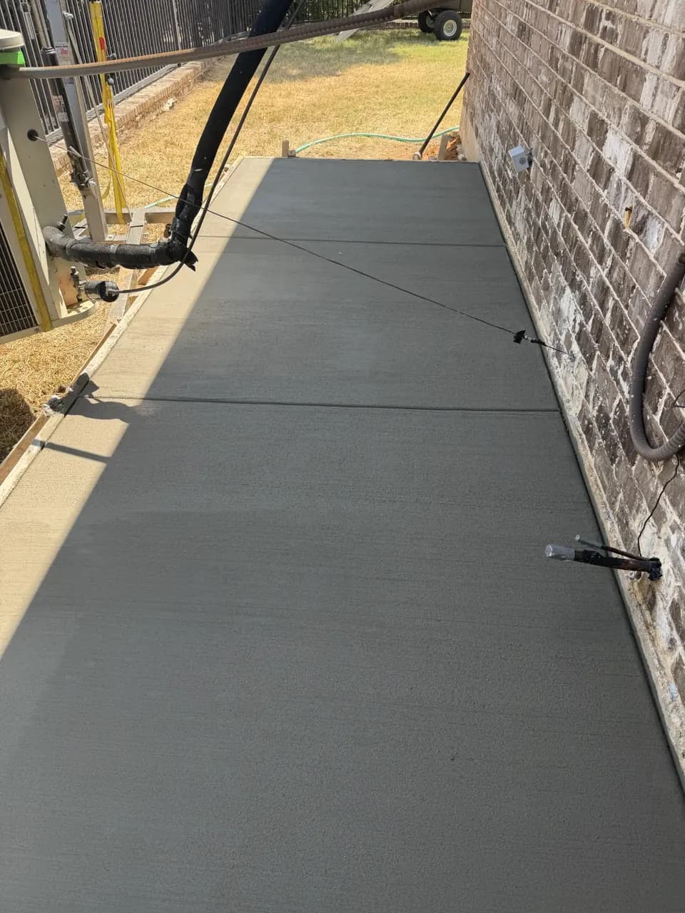 Concrete walkway beside a brick home